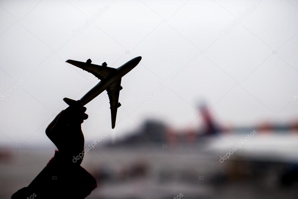 Silhouette of a small airplane model on airport background