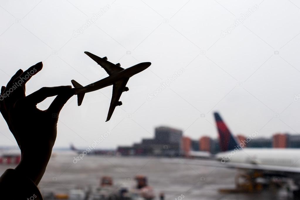 Silhouette of a small airplane model on airport background