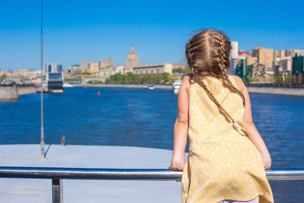 Little adorable girl on the deck of a ship sailing in big city — Stock Photo, Image