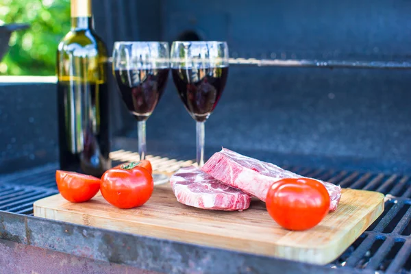 Carne fresca, verduras y botella de vino en barbacoa al aire libre —  Fotos de Stock