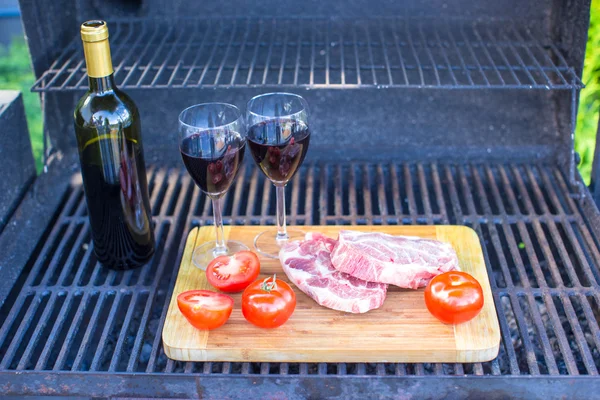 Carne fresca, verduras y botella de vino en un picnic al aire libre —  Fotos de Stock