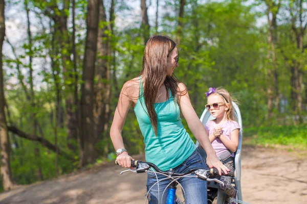 幸せな母と少しの娘公園で自転車をサイクリング — ストック写真