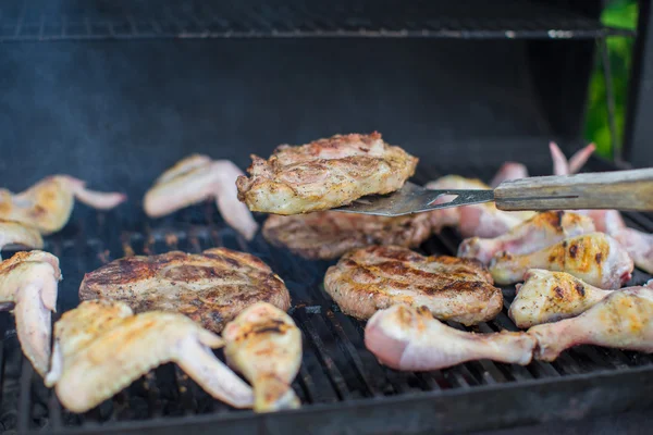 Grilovaný steak a vaření na otevřený barbecue kuřecí masíčka — Stock fotografie