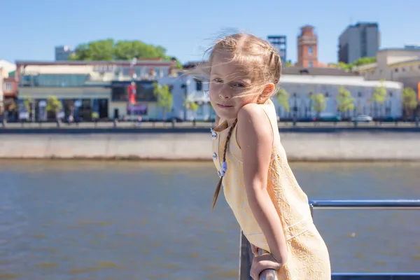 Niña adorable en la cubierta de un barco que navega en la gran ciudad —  Fotos de Stock