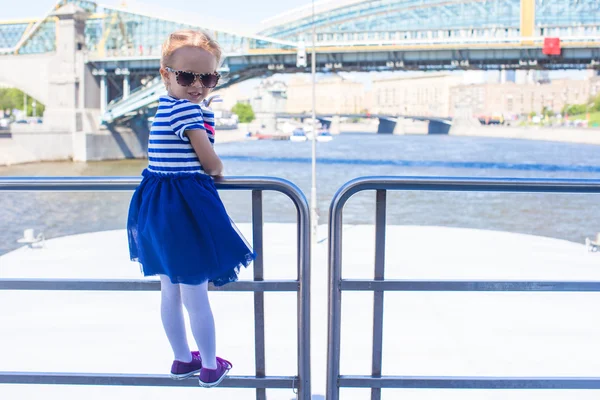 Pequena menina feliz relaxante no navio de luxo navegando na cidade grande — Fotografia de Stock