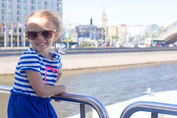 Šťastná holčička relaxační na luxusní lodi plující ve velkém městě — Stock fotografie