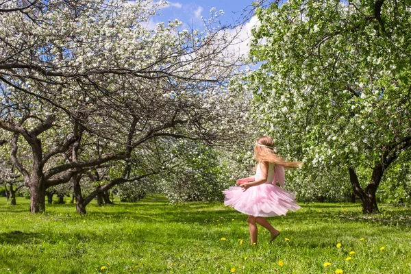 可爱的、长着蝴蝶翅膀的小女孩在开着的苹果园里玩得很开心 — 图库照片