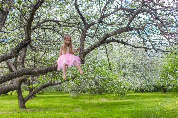 Liten bedårande flicka på blommande äppelträd — Stockfoto