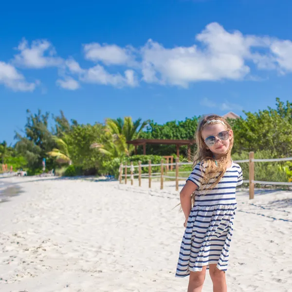 Nettes kleines Mädchen mit Sonnenbrille am Strand während der Sommerferien — Stockfoto