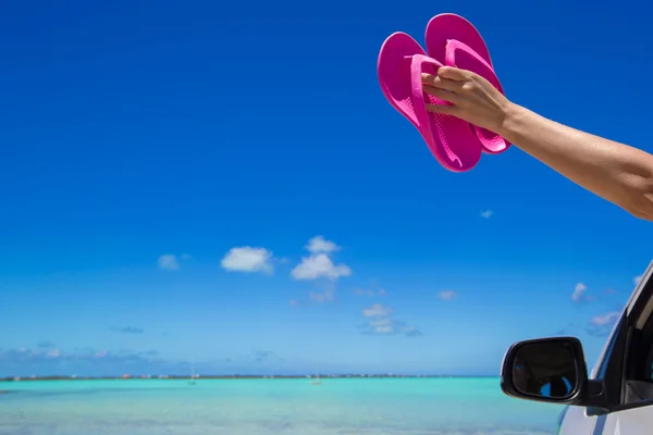 Flip Flops from the window of a car on background tropical beach — Stock Photo, Image