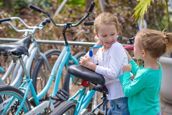 Schattige meisjes plezier in de buurt van de fietsen op exotische resort — Stockfoto