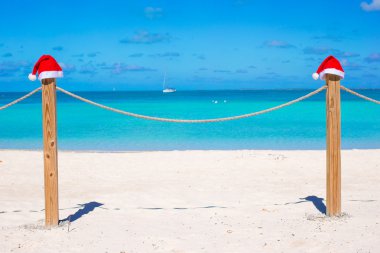 İki Noel Baba şapkaları çit tropikal beyaz Beach üzerinde