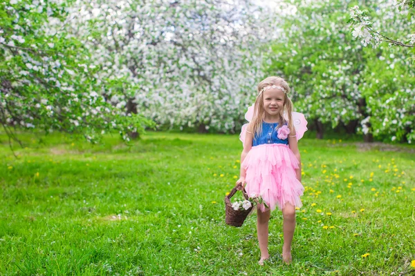 Menina adorável com cesta de palha no pomar de maçã florescente — Fotografia de Stock