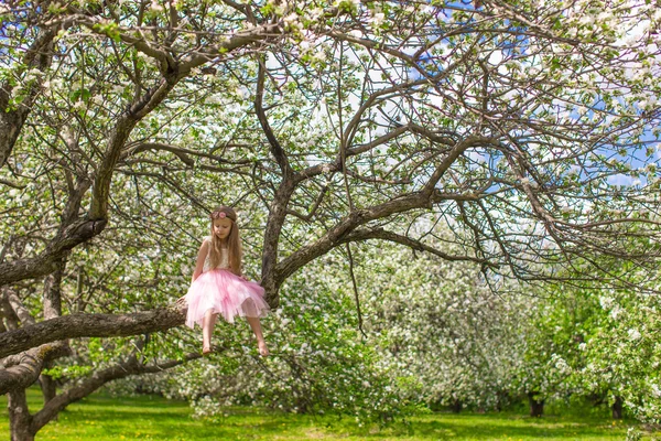 Adorable little girl have fun in blossoming apple orchard — Stock Photo, Image