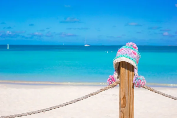 Primo piano caldo cappello a maglia sulla recinzione sulla spiaggia tropicale — Foto Stock
