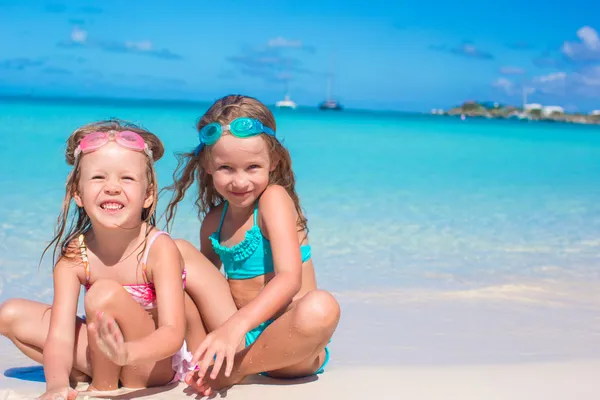 Niñas en gafas para nadar jugando con la arena en las vacaciones de verano —  Fotos de Stock