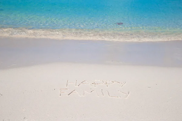 Familia feliz escrito en la playa tropical de arena blanca — Foto de Stock