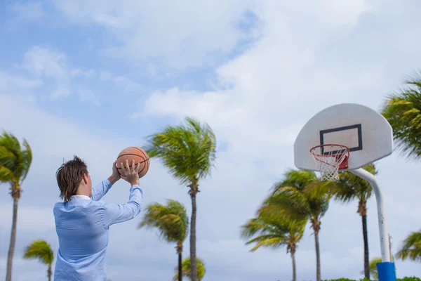 Jovem jogando basquete fora no resort exótico — Fotografia de Stock