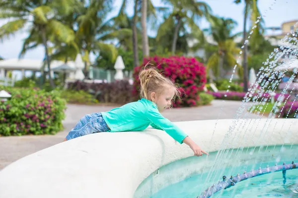 Little adorable girl in a beautiful exotic hotel near fountain — Stock Photo, Image