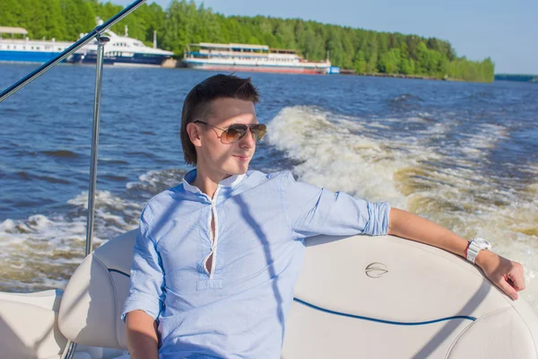 Jonge man zwemmen en rusten op zijn jacht op zonnige dag — Stockfoto