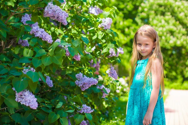 Adorable little girl in blossoming lilac flower garden — Stock Photo, Image