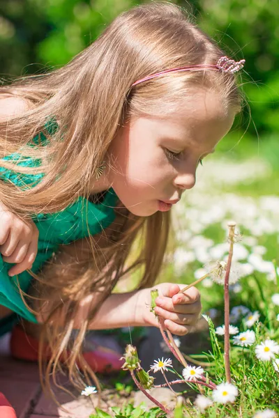 Portrait d'adorable petite fille soufflant un pissenlit dans le jardin — Photo