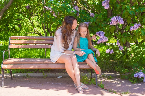 幸福的母亲和可爱的女孩，在苍翠繁茂的花园里享受温暖的一天 — 图库照片