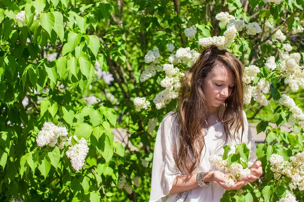 白いライラックの庭で若い美しい女性を楽しむ春の日 — ストック写真