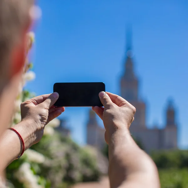 Zblízka telefon pozadí vysoké budovy ve velkém městě — Stock fotografie