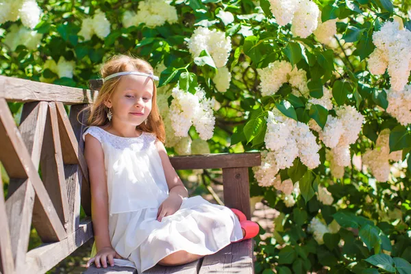 Adorable happy little girl in flower blossoming garden — Stock Photo, Image