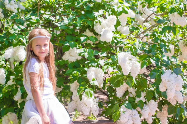 Lilla flickan har roligt i blomma blommande trädgård — Stockfoto