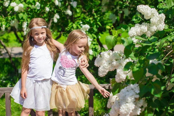 Kleine entzückende Mädchen genießen Wochenende im schönen blühenden Garten — Stockfoto