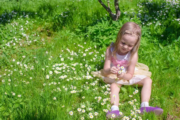 Liten bedårande flicka på grön blomma glade — Stockfoto