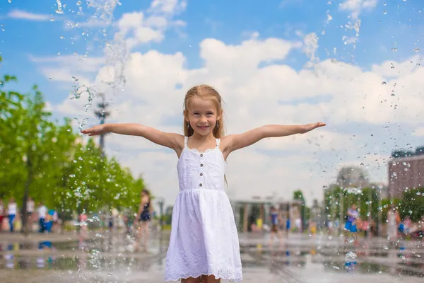 Niña linda caminando en la fuente de la calle abierta en el día soleado caliente —  Fotos de Stock