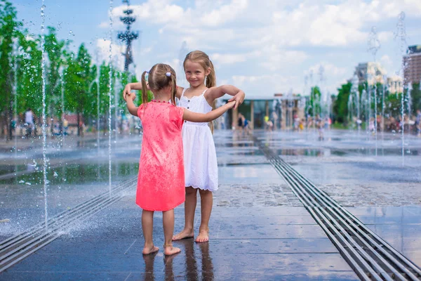 Kleine Mädchen genießen sonnigen Tag im offenen Straßenbrunnen — Stockfoto