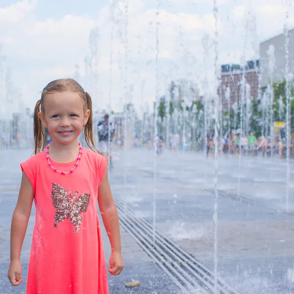 Retrato de menina adorável pouco se divertir na fonte da rua no dia ensolarado quente — Fotografia de Stock