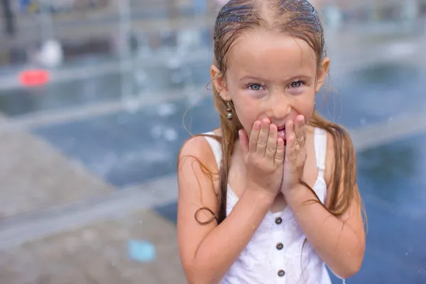 Retrato de la niña mojada feliz en la fuente de la calle en el día soleado caliente —  Fotos de Stock