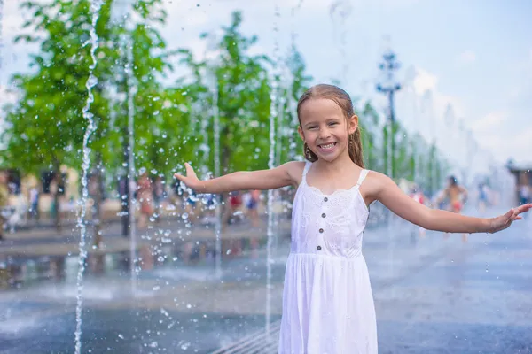 Ritratto di piccola ragazza felice bagnata in fontana di strada nella calda giornata di sole — Foto Stock