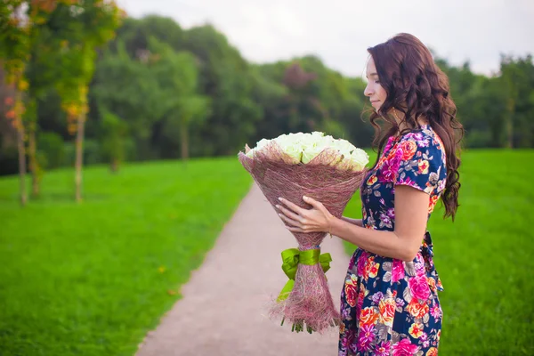 Hermosa joven con gran ramo de rosas blancas — Foto de Stock