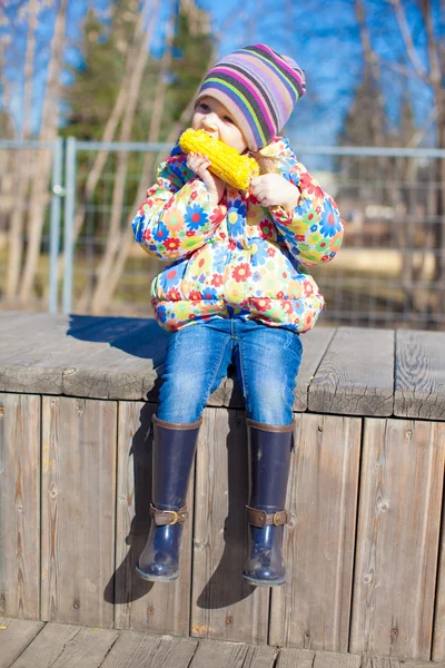 Little adorable girl eating corn in the park outdoor — Stock Photo, Image