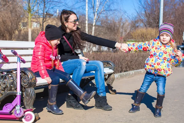 Young mother and little happy girls enjoy sunny day in the park — Stock Photo, Image