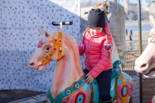 Schattig meisje op carrousel op zonnige dag buiten — Stockfoto