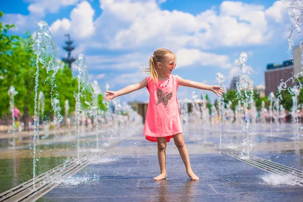 Little happy girl playing in open street fountain at hot sunny day — Stock Photo, Image