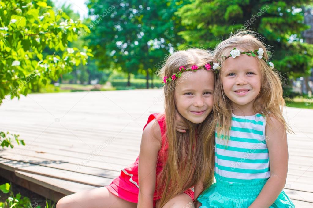 Happy adorable little girls on warm summer day