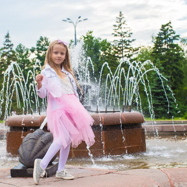 Liten bedårande flicka i vacker klänning nära fountain — Stockfoto