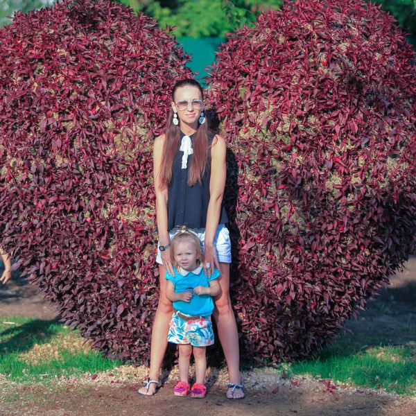 Petite fille avec sa mère profiter d'une journée chaude dans le jardin en fleurs — Photo