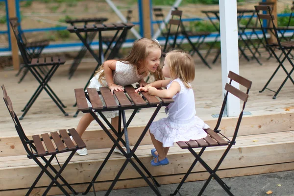 Little funny girls at outdoor cafe on warm summer day — Stock Photo, Image