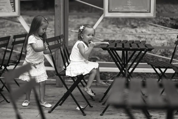 Little happy girls have fun at outdoor cafe — Stock Photo, Image