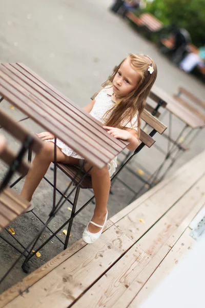 Little adorable girl at outdoor cafe on warm summer day — Stock Photo, Image