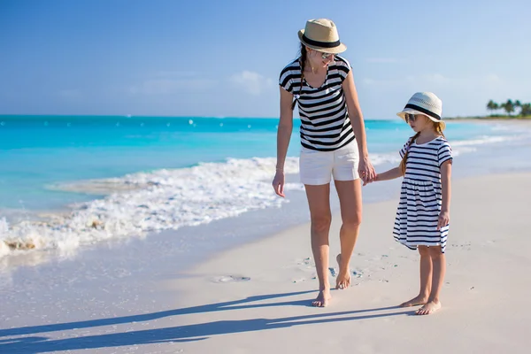 Giovane madre che cammina con sua figlia lungo la spiaggia di caraibi — Foto Stock